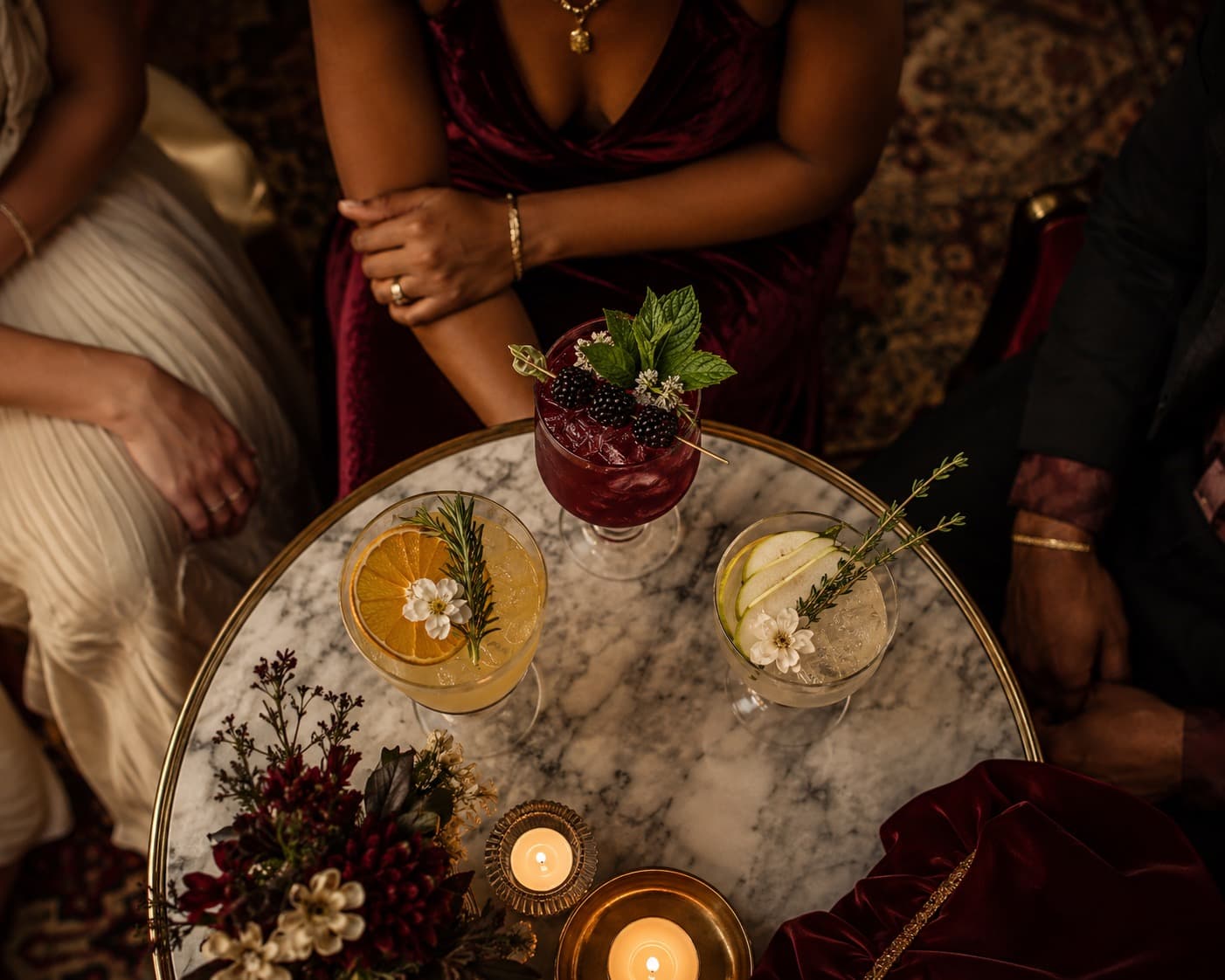 Three alcohol-free drinks with citrus, blackberry and pear garnish